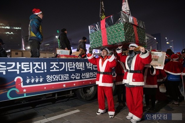 지난 24일 밤 서울 광화문광장에서 박근혜 정권 퇴진 청년행동 회원들이 산타 복장을 입고 퍼포먼스를 하고 있다. / 사진=최혁 한경닷컴 기자